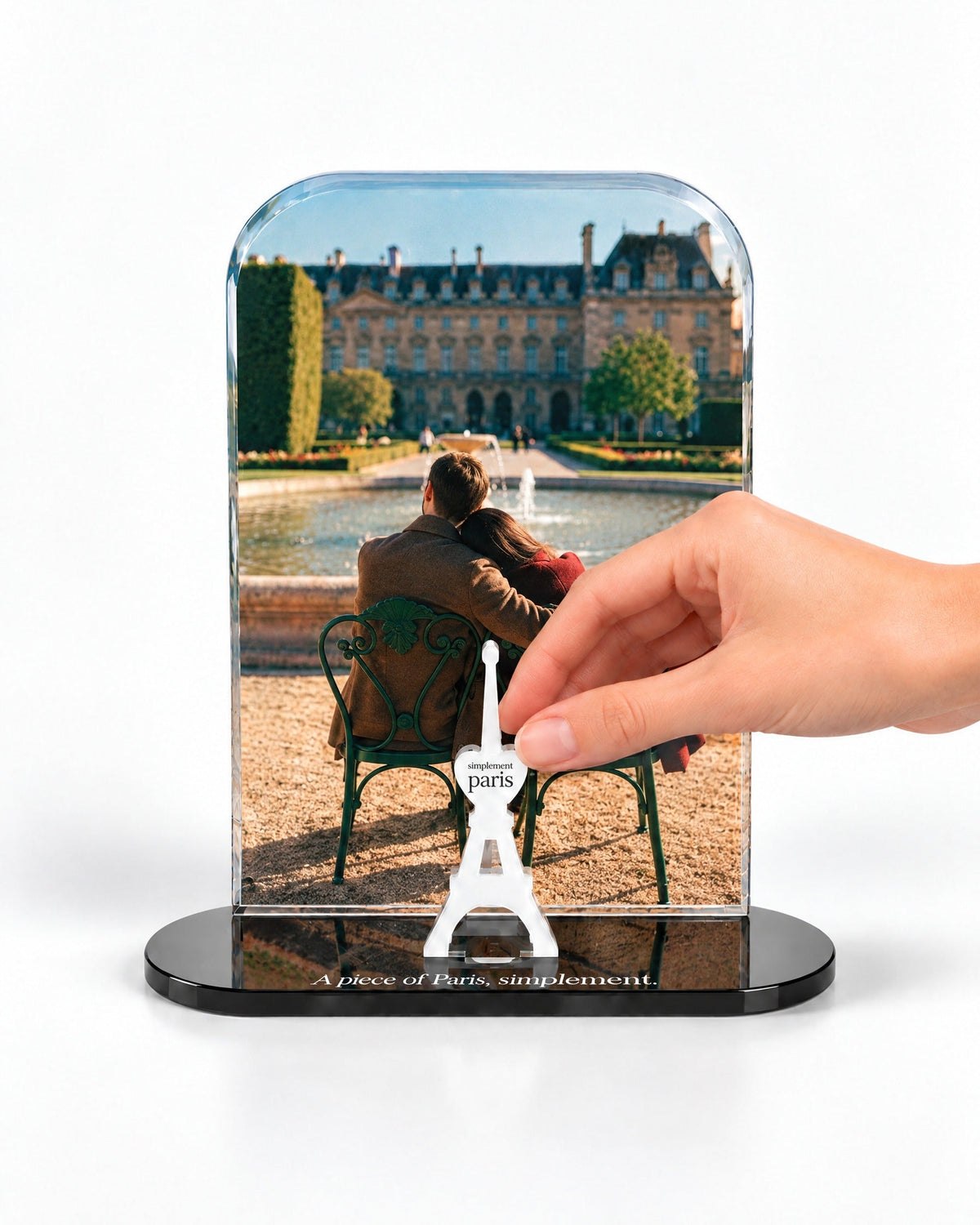 A hand placing the white signature Eiffel Tower in front of the Paris for Two acrylic panel