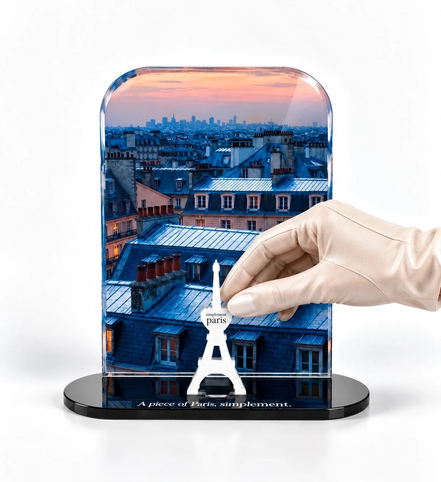 A hand placing the signature Eiffel Tower on a Simplement Paris acrylic piece